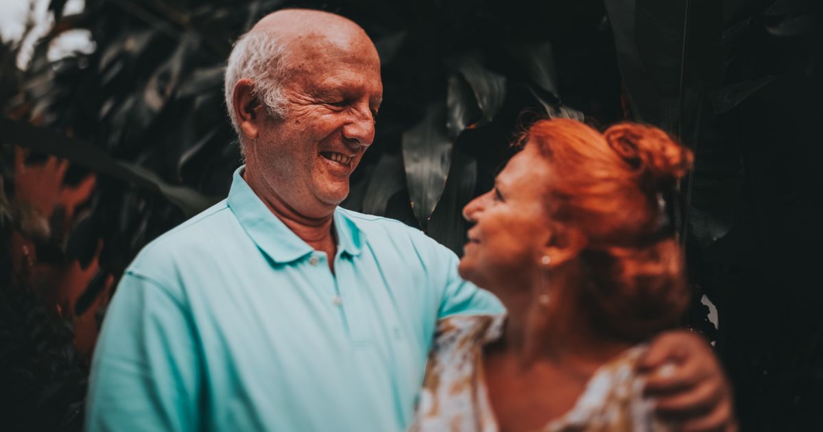 Casal de idosos sorrindo abraçados