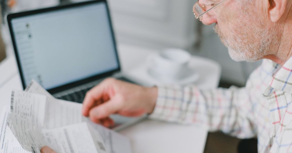 Homem idoso de óculos lendo documento
