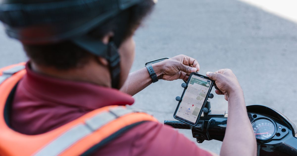 Entregador conferindo rota no aplicativo do smartphone