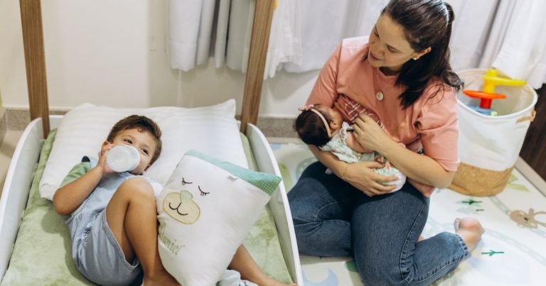 Mãe com bebê e criança pequena em casa