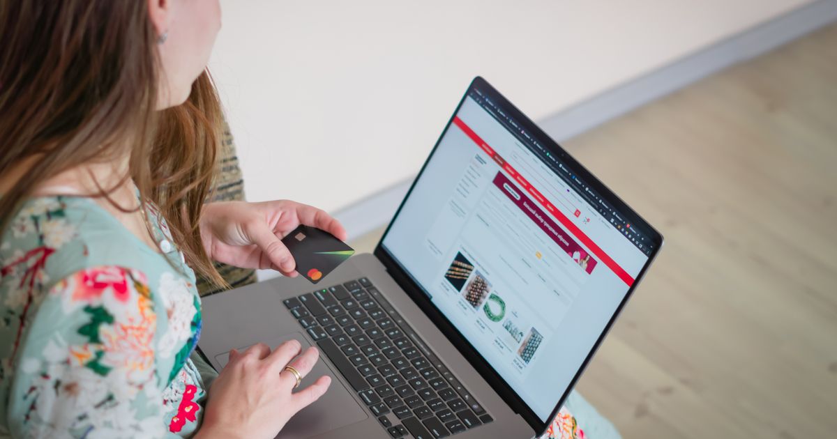 Mulher comprando online com laptop e cartão de crédito