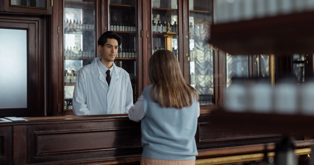 Farmacêutico atendendo cliente no balcão da farmácia