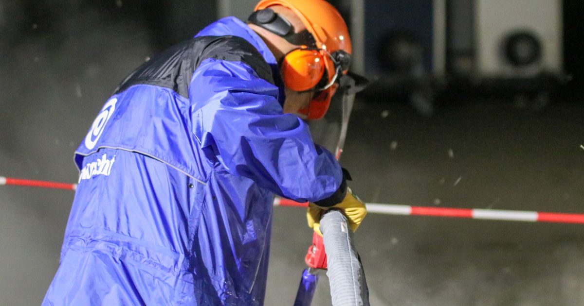 Trabalhador industrial com equipamento de proteção operando máquina