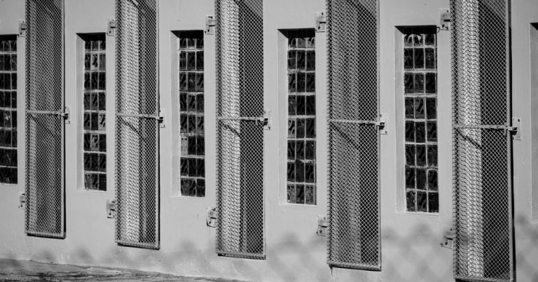 Janelas gradeadas de um prédio em preto e branco